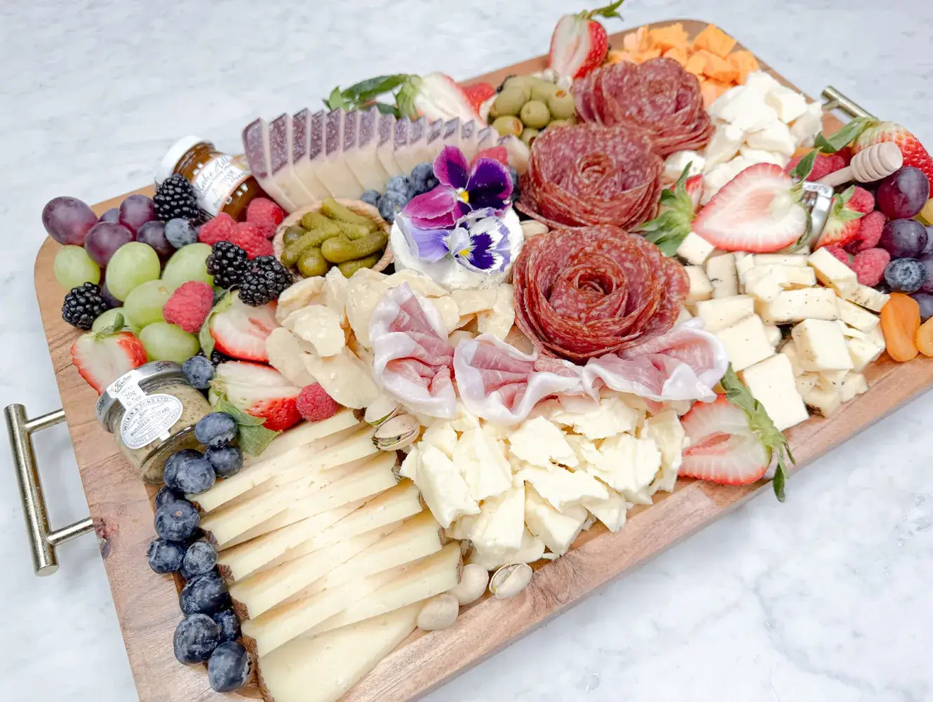 Orange County charcuterie board by Fork and Flare styled with hand cut cured salami and prosciutto, manchego, brie, aged gouda, wine soaked cheese, espresso cheddar, rustic red cheddar, Boursin, sheep’s milk and goat cheeses, olives, cornichons, strawberries, blueberries, blackberries, grapes, honey, jam and stone ground mustard for local delivery or pickup.