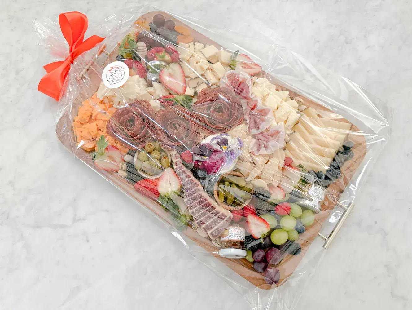 Orange County charcuterie board by Fork and Flare with hand cut cured salami and prosciutto, manchego, brie, aged gouda, wine infused cheese, espresso cheddar, rustic red cheddar, Boursin, sheep’s milk and goat cheeses, olives, cornichons, strawberries, blueberries, blackberries, grapes, honey, jam, and stone ground mustard available for delivery or pickup.