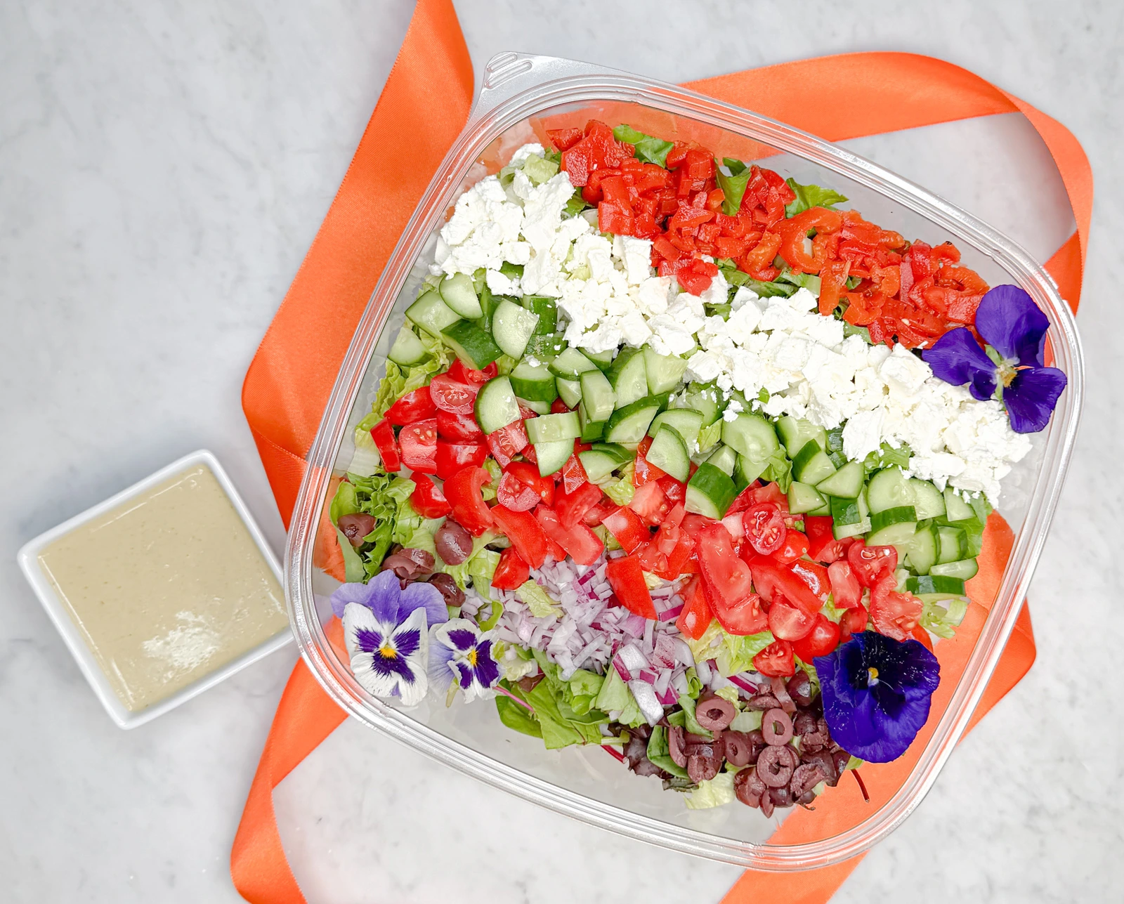 Best salad in Orange County shown as a large 160 ounce Chopped Mediterranean Salad by Fork and Flare featuring freshly chopped romaine lettuce, diced red onion, Kalamata olives, tomatoes, cucumber, and creamy feta