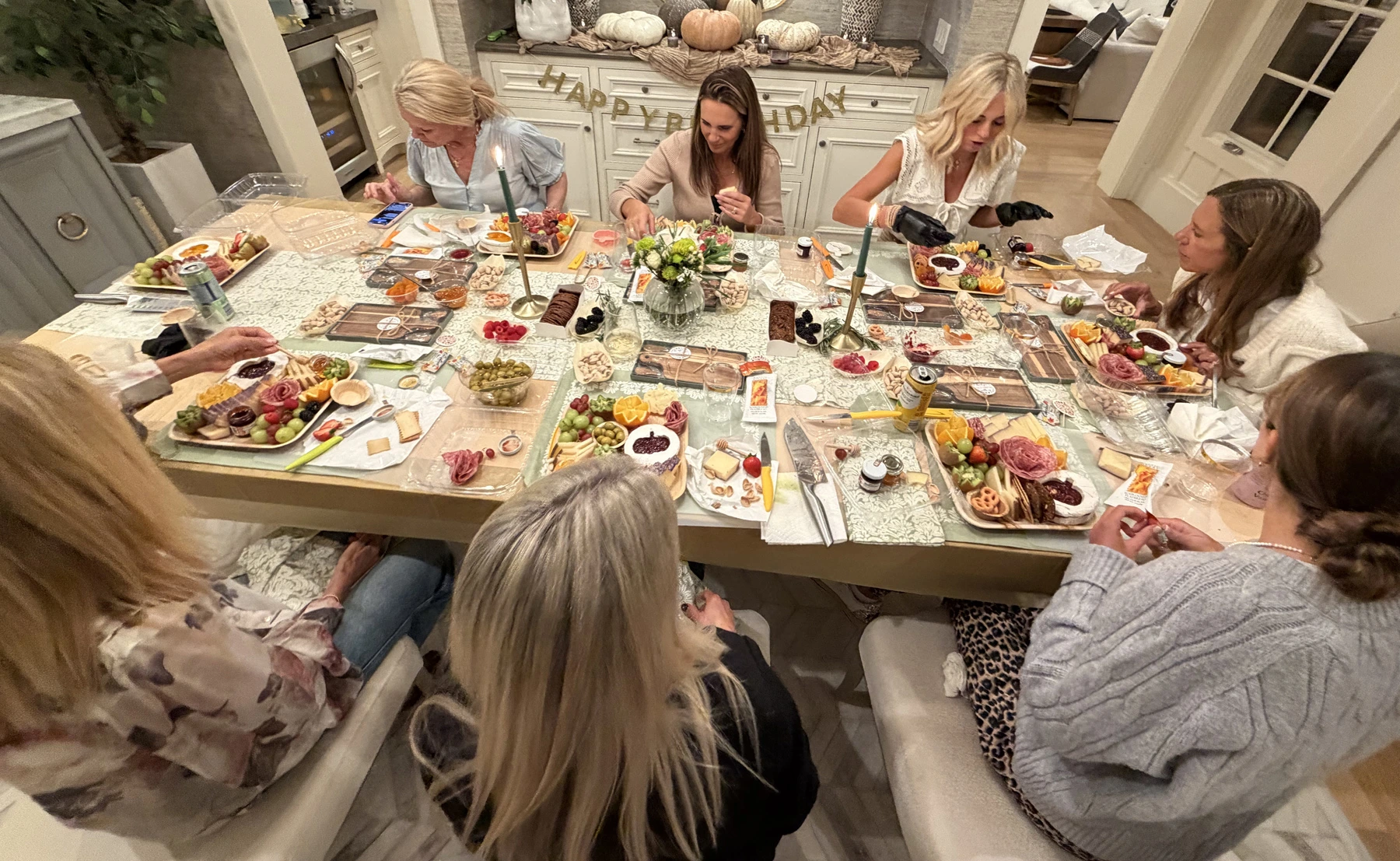 Best charcuterie workshop in Newport Beach is captured in this Fork and Flare image, showing happy women seated at a shared table creating individual charcuterie boards with artisan cheeses and cured meats during a team building experience designed for events, celebrations, birthdays, and group gatherings by Fork and Flare in Newport Beach.