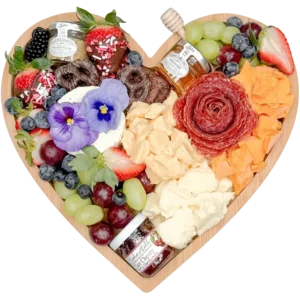 Date night heart shaped charcuterie board by Fork and Flare serving 2 to 3 people with chocolate covered strawberries, Rustic Red cheddar cheese, Prairie Breeze white cheddar, Gouda cheese, Boursin cheese, imported hand cut salami, fresh strawberries, blackberries, grapes, chocolate covered pretzels, jam, honey, and stone ground mustard, styled as a romantic grazing board in Orange County, California.