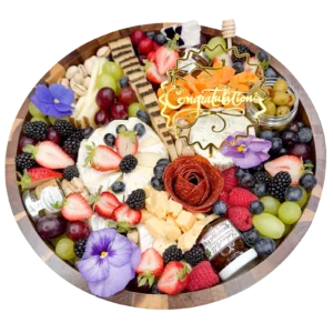 Fruit and cheese board with grapes, berries, cheese wedges, crackers, and a gold 'Congratulations' topper with edible flowers.